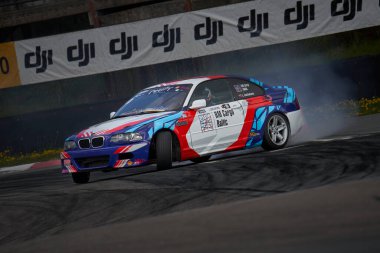 21-05-2022 Riga, Letonya arabası asfalt yarış pistinde sürükleniyor çok fazla duman ve hareket bulanıklığı olan..