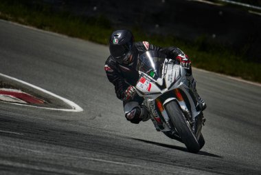 12-09-2022 Riga, Letonyalı adam asfalt yolda motosiklet sürüyor. Spor motosikletinde motosikletçi. Yoldaki motosiklet yarışçısı