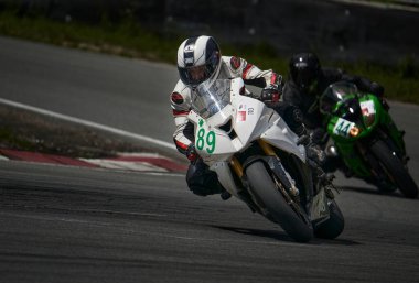 12-09-2022 Riga, Letonyalı adam asfalt yolda motosiklet sürüyor. Spor motosikletinde motosikletçi. Yoldaki motosiklet yarışçısı