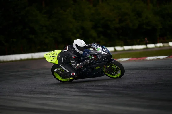 2022ラトビアのリガ路上で赤いバイクに乗っている男 人は路上でオートバイに乗っている — ストック写真