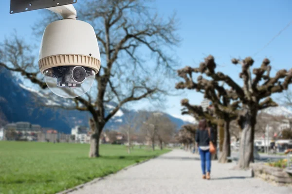 CCTV kamera med en kvinna gå ensam i bakgrunden — Stockfoto