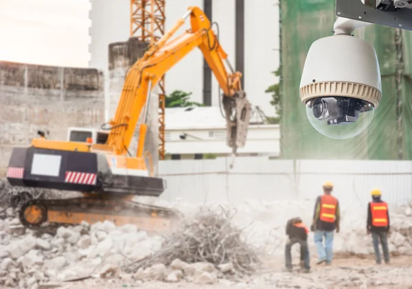 Cctv-Kamera beobachtet einen Bagger und Arbeiter bei der Arbeit auf einer Baustelle — Stockfoto