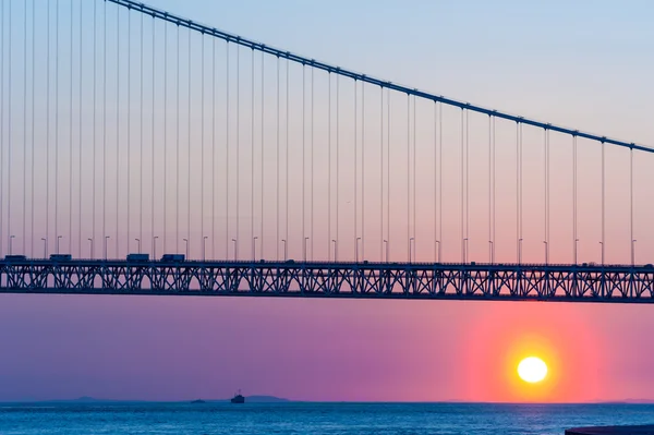 神戸港、J で夕暮れの空に明石海峡大橋と夕日 — ストック写真