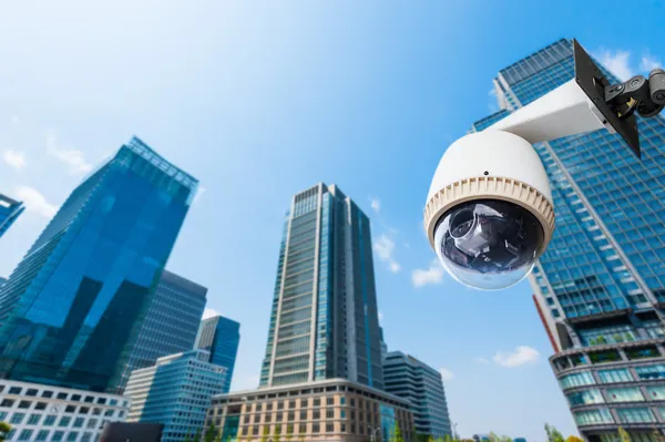 CCTV kamera eller övervakning oeprating med byggnad i bak — Stockfoto