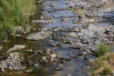 Baile Sacelu, Gorj County, Romania  July 24, 2022: The bed of the Blahnita River in Baile Sacelu, Gorj, Romania. Here we meet various geological formations.