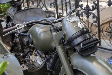 Hunedoara, Hunedoara County - July 22, 2022:  Old motorcycle from the equipment of the Soviet army, exhibited as a decoration at the Vintage restaurant in Hunedoara, Transylvania, Romania. 