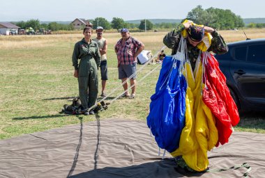 Stanesti, Gorj, Romania  August 27, 2022:  Military paratroopers prepare the parachute for launch at the air show at the Stanesti aerodrome, Gorj, Romania