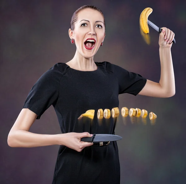 Menina corta uma banana. — Fotografia de Stock