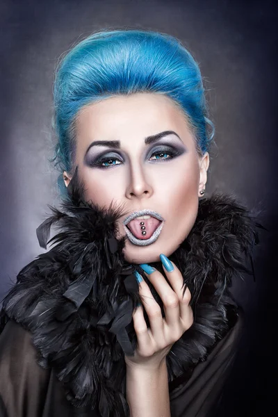 Дівчина з блакитним волоссям показує проколотий язик . — стокове фото