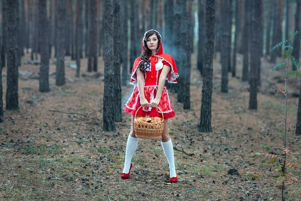 Schönes Mädchen in rotem Regenmantel allein im Wald. — Stockfoto