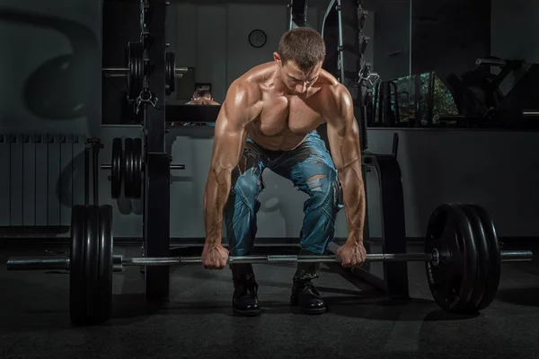 Male bodybuilder raises the bar. — Stock Photo, Image