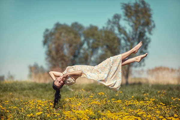 Mädchen schwebt über dem Feld. — Stockfoto