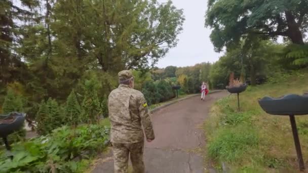 ウクライナ軍の父は娘の元に戻った 軍の男と少女は手をつないで行く — ストック動画