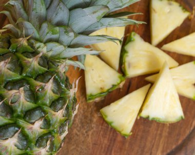 photo of pieces of pineapple on a board. close up, top view.