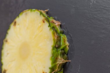 pineapple slice on a wet stone slab.