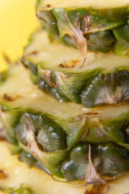 macro photo of chopped fresh pineapple. vertical photo of pieces of us with bark