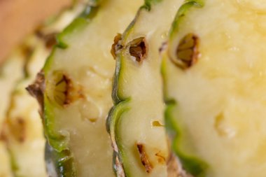 horizontal macro photo of sliced fresh pineapple. photo of pieces of pineapple with bark
