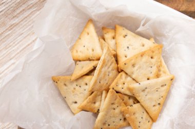 Çıtır üçgen krakerlerin üst görüntüsünü kapat. Tuzlu ve haşhaş tohumlu diyet gevreği.