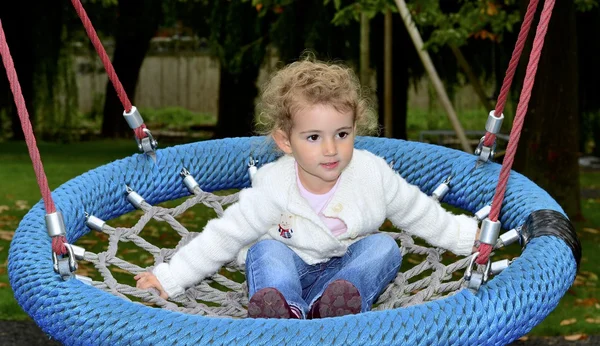 Criança pequena brincando em um balanço — Fotografia de Stock