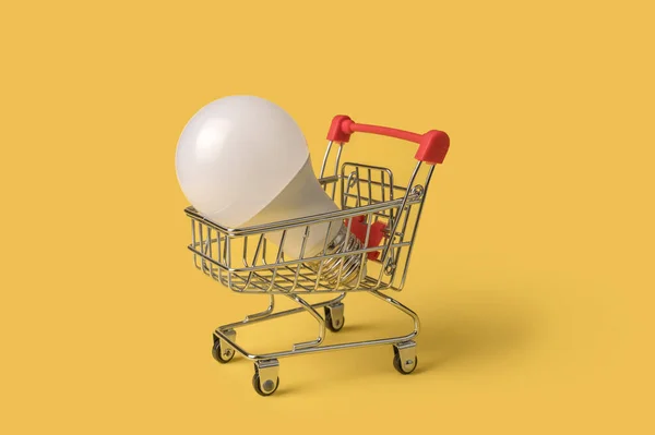 Shopping cart with a light bulb. Mini cart. Online purchase of light bulbs.
