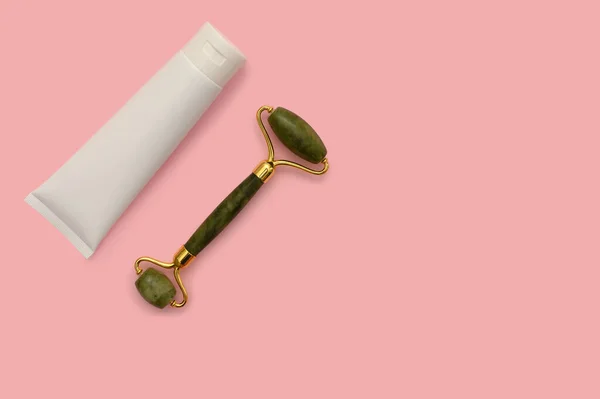 Cosmetic roller for the face, white container on a pink background. — Stock fotografie