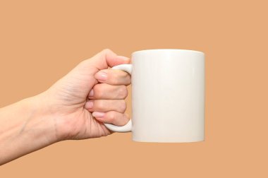A female hand holds a white mug. Minimalism and space for text.