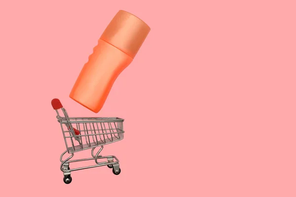 在一个铁质的小篮子里有奶油的橙色容器 网上买卖 粉红的背景 — 图库照片