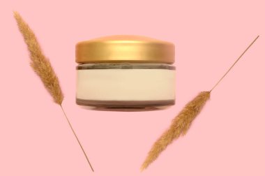 Kozmetik beyaz krem ve pembe arka planda kuru çiçekler. Yakın plan..