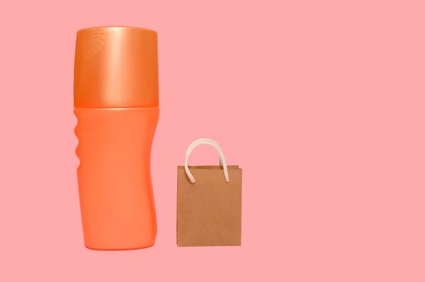 오렌지 플라스틱 용기. 쇼핑백이요. 분홍빛 배경에. — 스톡 사진