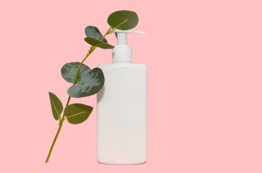 Mockup beyaz konteynır ve okaliptüs dalı. Pembe arka planda. Metin için yer.