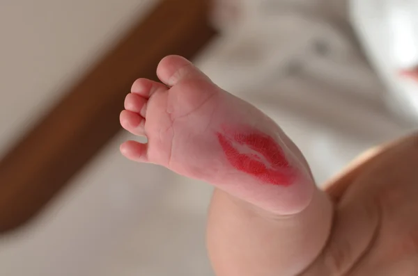 Lippenstift-Kuss auf Babys Bein lizenzfreie Stockbilder