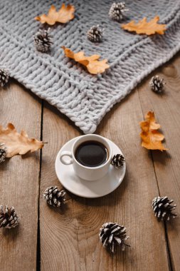 Kurabiye, yaprak ve koni ile ahşap bir masada bir fincan kahve.