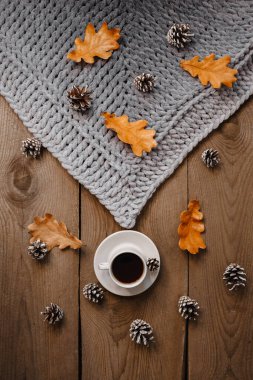 Kurabiye, yaprak ve koni ile ahşap bir masada bir fincan kahve.
