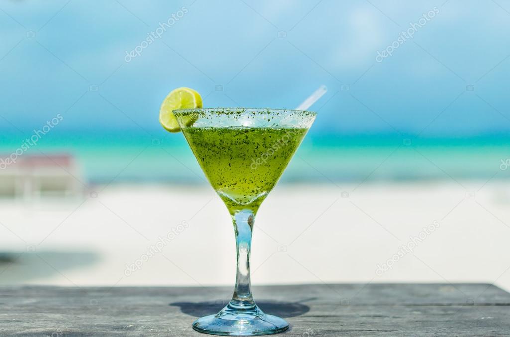 Fresh Margarita cocktail on a table at tropical white caribbean beach