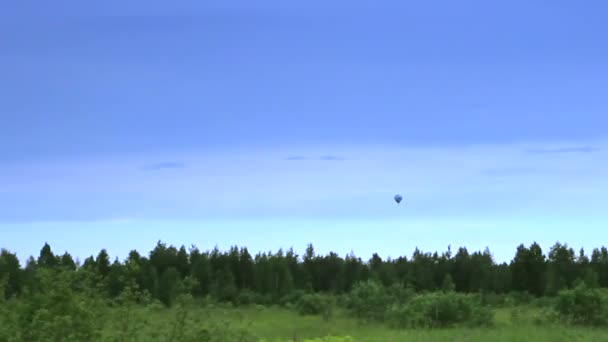 Globo de aire caliente aterrizando en el cielo azul — Vídeo de stock