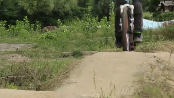 BMX rider in helmet spinning wheels on circuit race competition — Stock Video