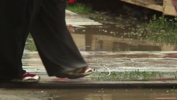 Gente piernas caminando en charcos cambio climático — Vídeos de Stock