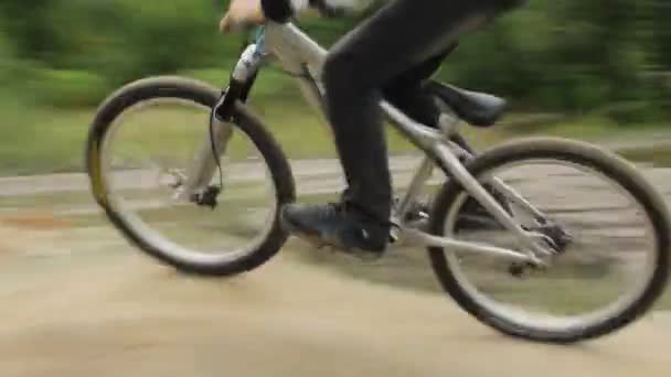 Bicicleta ciclista BMX carreras pista difícil, ruedas giratorias durante el día — Vídeo de stock
