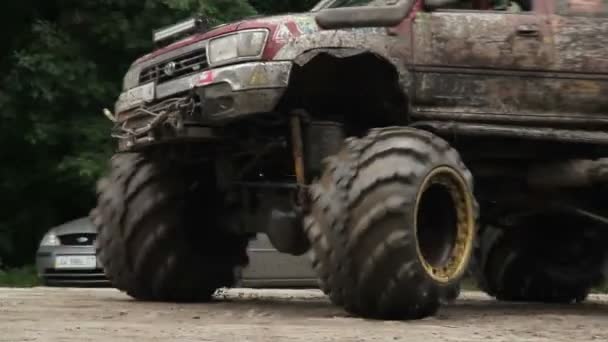 Bewegend grote grote-voet voertuig volledig in modder en vuil wielen — Stockvideo