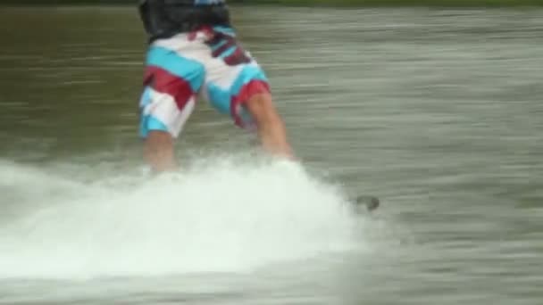 Wakeboarder male legs ride on water surface — Stock Video