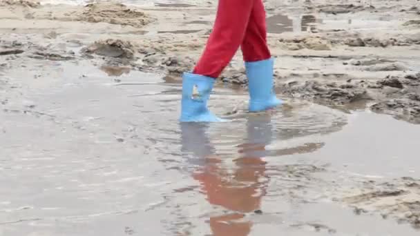 Les pieds d'enfant marchent sur la boue de la flaque — Video