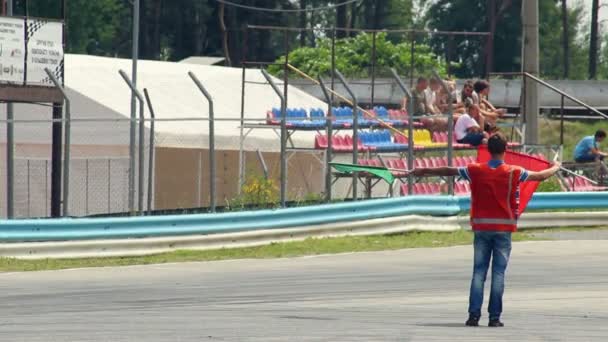 Hombre con bandera roja conduce coches — Vídeo de stock