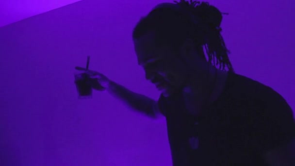 Afro DJ пьет коктейль в ночном клубе — стоковое видео