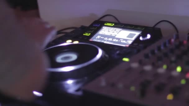 DJ в наушниках выступает в ночном клубе — стоковое видео