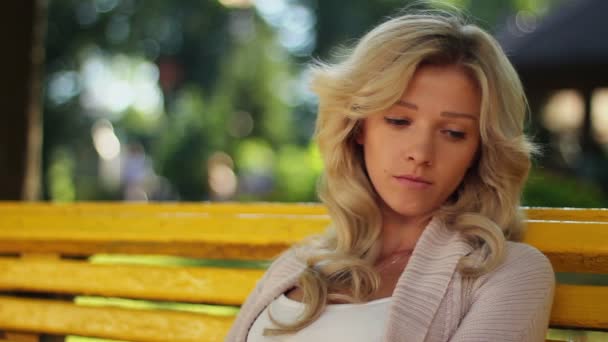 Traurige Erinnerung, Reminiszenz Frau sitzt deprimiert im Park, unglücklich — Stockvideo
