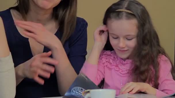 Twee vrouwen met een klein meisje in café — Stockvideo
