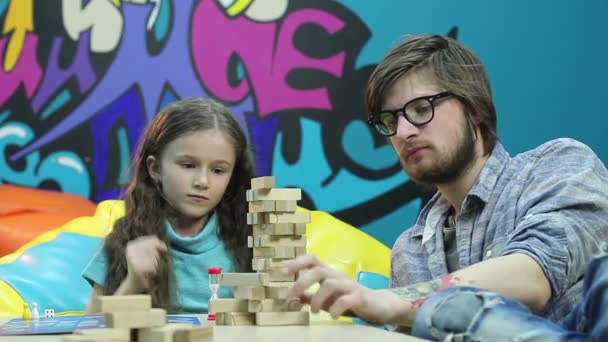 Niña jugando juego con el hombre joven — Vídeo de stock