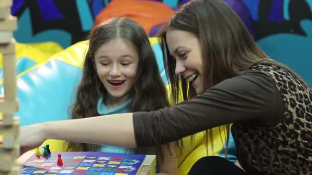 Meisje speelt bordspel met zus — Stockvideo