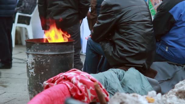 Pobre gente calentándose cerca del barril de basura de fuego — Vídeo de stock