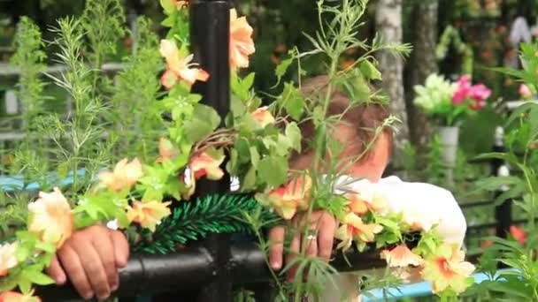 Weinender Mann auf Friedhof stützt sich auf Kreuz — Stockvideo